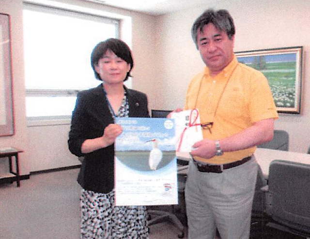 メニコンは稲わら分解促進材の売り上げの一部をトキ保護に寄付している（右から田中英成社長、新潟県の担当者）