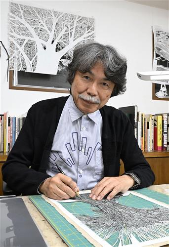 アトリエで切り絵を制作する久保修さん=東京都杉並区