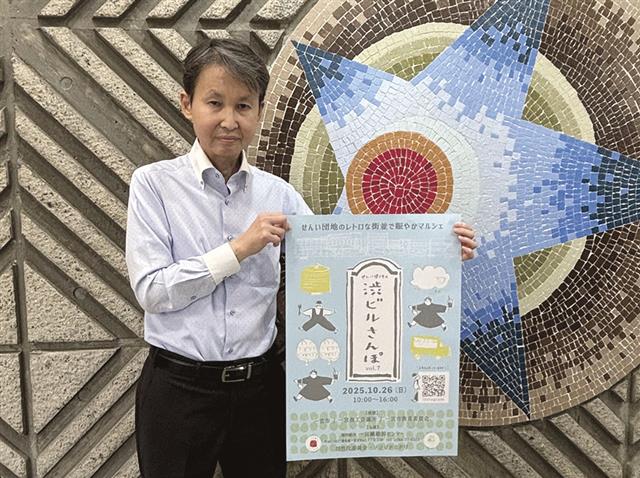 ポスターを掲げる栗山事務局長