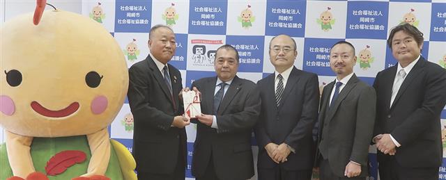 市社協の太田会長に目録を手渡す永田会長(右から4人目)