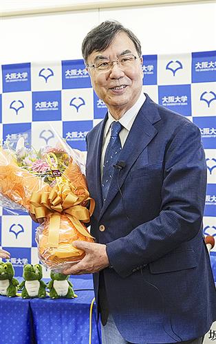ノーベル生理学・医学賞の受賞が決まり、記者会見場で花束を手に笑顔を見せる大阪大の坂口志文特任教授=6日、大阪府吹田市