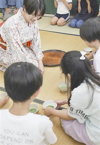 茶の湯体験で茶わんを手にする子どもたち=9月、京都府京田辺市