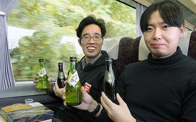 長野県内のJR飯田線を走る特別列車で伊那地域の酒を楽しむ乗客=25日午前
