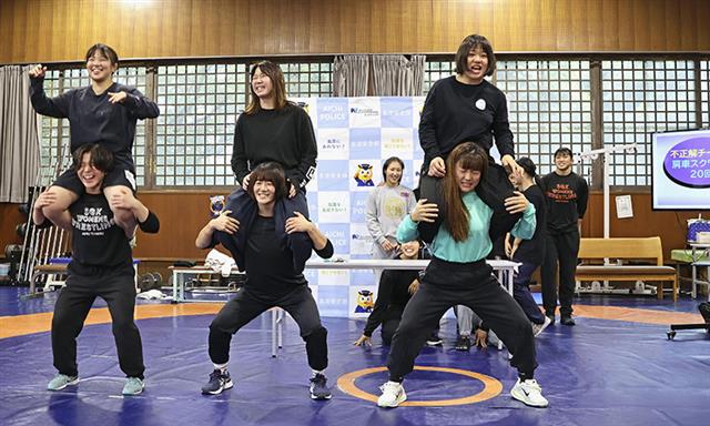 特殊詐欺手口のクイズ「防犯トレーニング」に挑戦し、課されたトレーニングをする至学館大の女子レスリング部員ら=25日午前、大府市