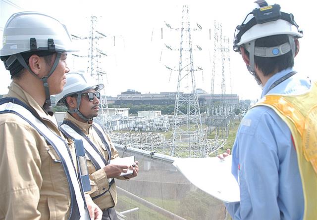 工事現場を見学するオクトヴィアーノさん(中)と正田社長(左)