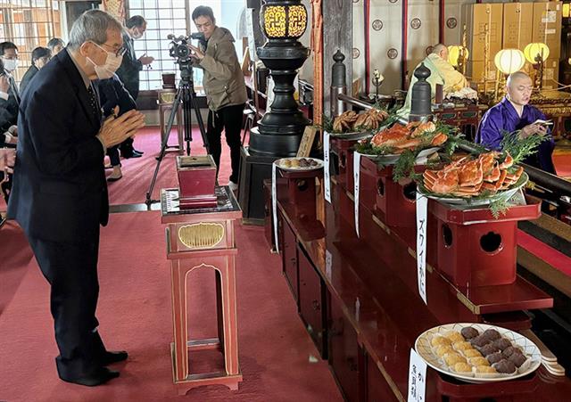 かに供養で手を合わせる日置会長