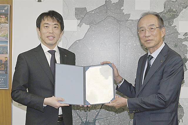 名駅南エリアマネジメントの近藤代表理事(右)と名古屋市の伊藤住宅都市局長