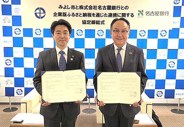 協定書を取り交わした小山市長と清水常務(右)