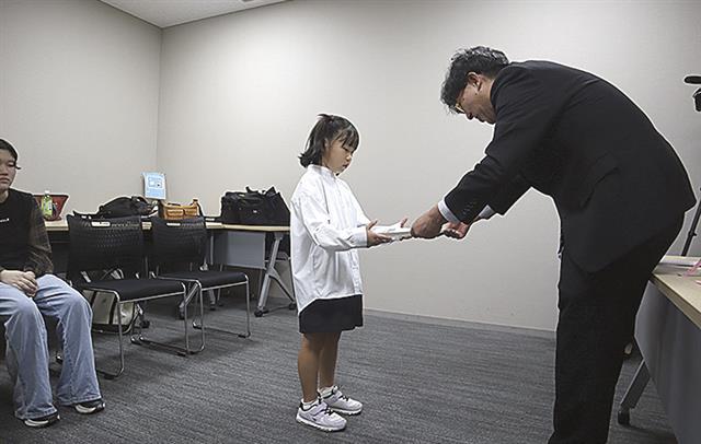 感謝状を手渡す八巻会長(右)