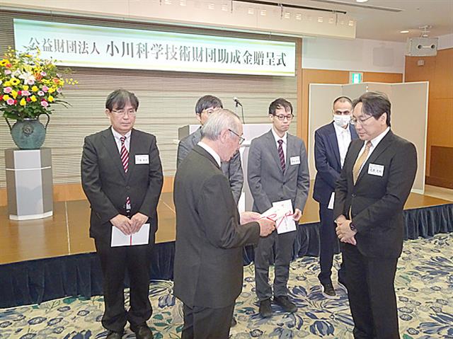 研究者に目録を手渡す小川理事長(手前左)