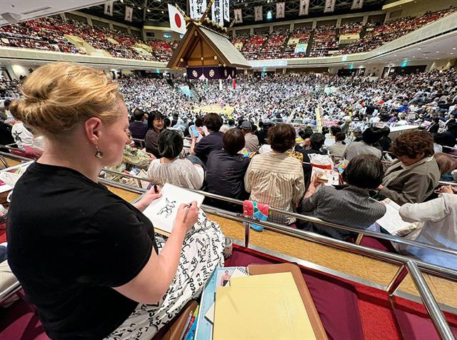 両国国技館で力士のスケッチをするゾヤ・スコロパデンコさん=東京都墨田区(本人提供)