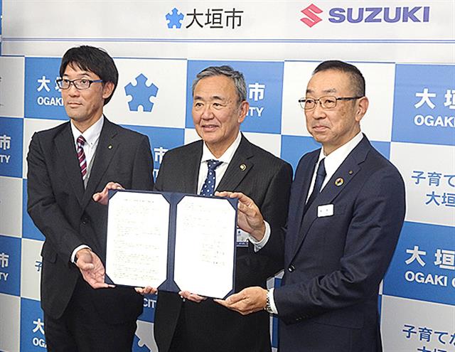 協定書を掲げる加藤社長、石田市長、長野営業部長(左から)