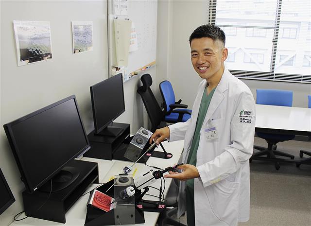 手術のトレーニング器具を手に「手術をする時は、仲間とのコミュニケーションを大切にしています」と話す山本悠太さん=長野県松本市