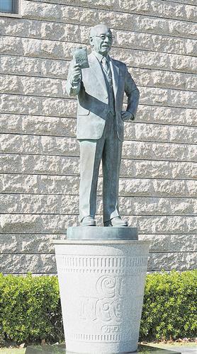 右手に「チキンラーメン」を持ち、「カップヌードル」の台座に立つ安藤百福さんの銅像=大阪府池田市の「安藤百福発明記念館」