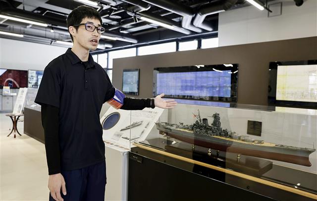 「大和ミュージアムサテライト」で、展示について説明する学芸員の濱名翔平さん=10月、広島県呉市